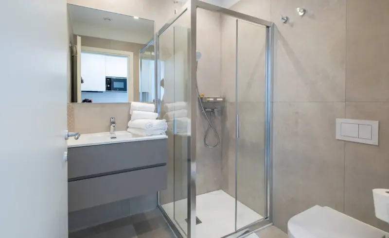 Bagno luminoso con doccia in vetro.