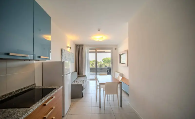 Cucina moderna con tavolo e vista sul balcone.