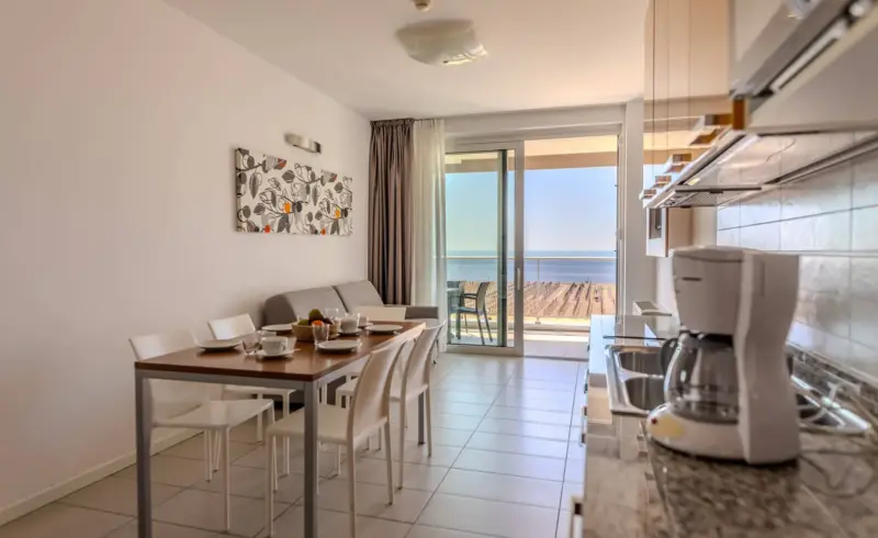 Cucina moderna con vista mare, tavolo apparecchiato.