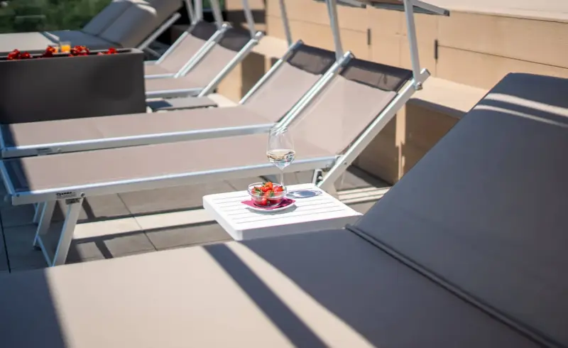 Lettini in terrazza con bicchiere di vino.