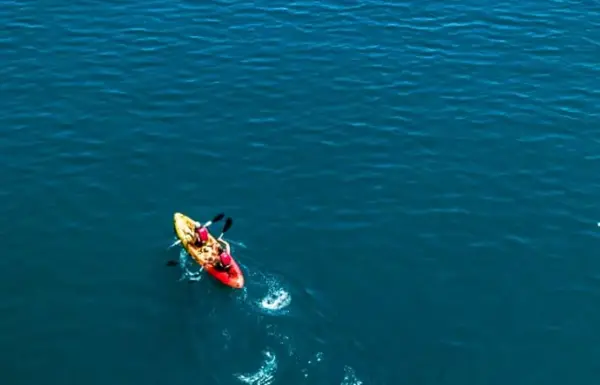 Persona che fa kayak su un ampio lago.