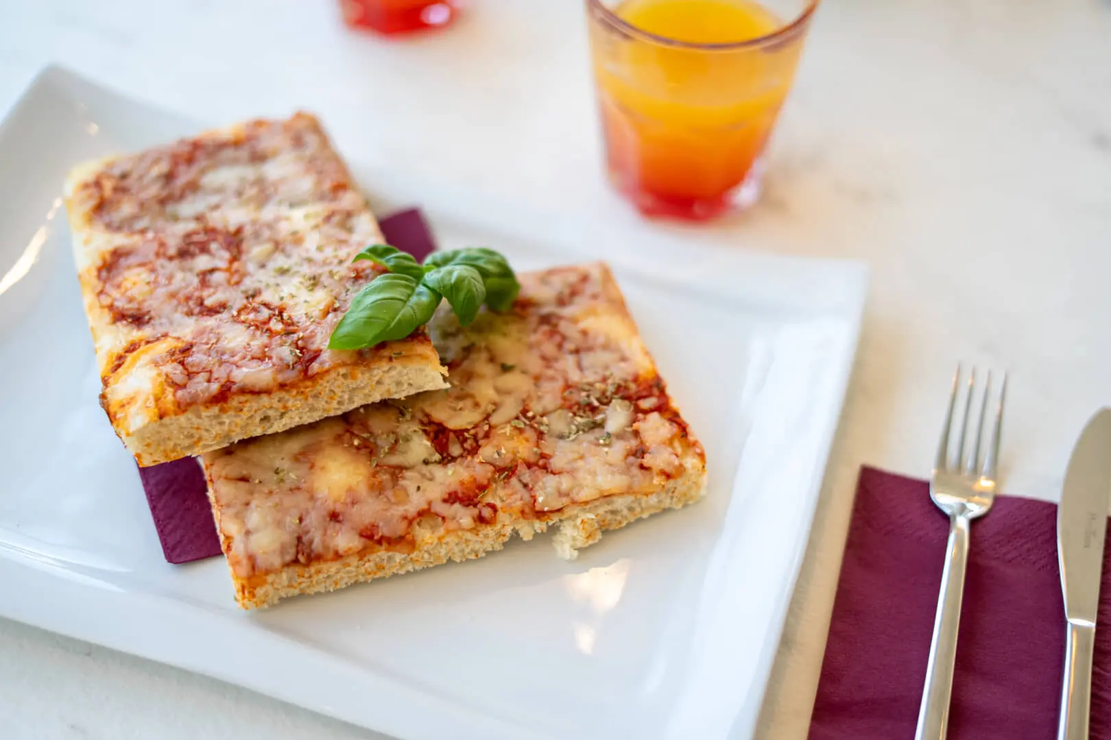 Due fette di pizza con basilico su piatto.