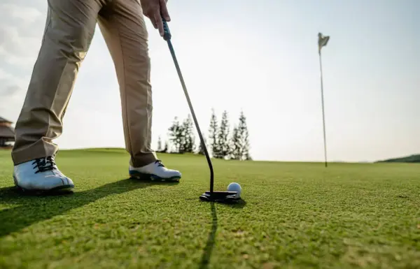 Golfista mentre si prepara a colpire la palla.