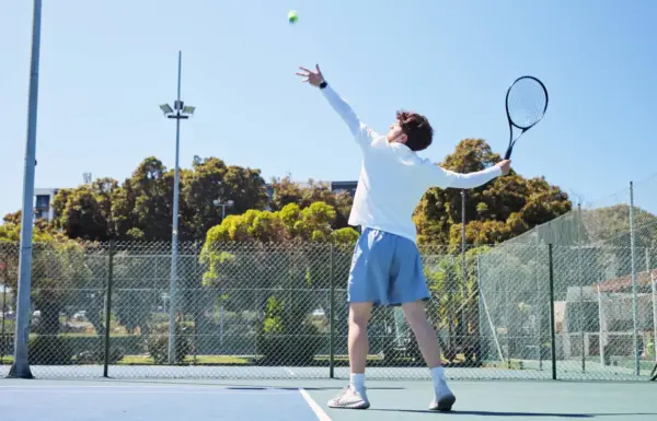 Giocatore di tennis serve una palla sul campo.