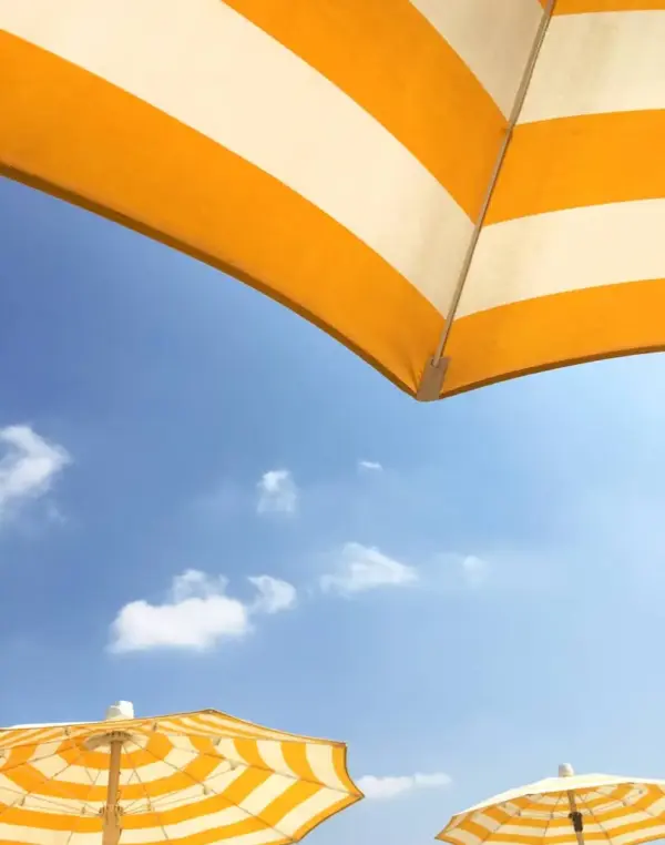 Ombrelloni gialli sotto il cielo blu.