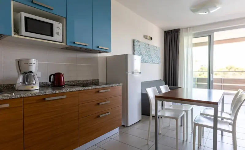 Cucina moderna con elettrodomestici e tavolo da pranzo.