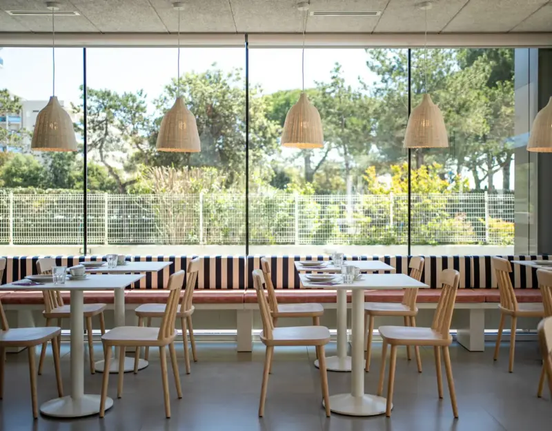 Ristorante moderno con ampie finestre e arredamento luminoso.