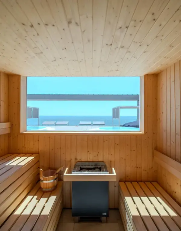 Sauna in legno con vista sul mare luminoso.