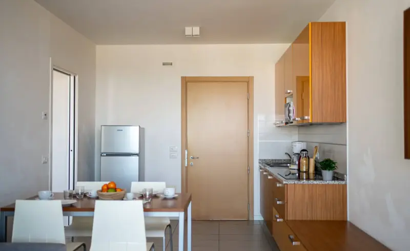 Cucina moderna con tavolo, frigorifero e mobili in legno.