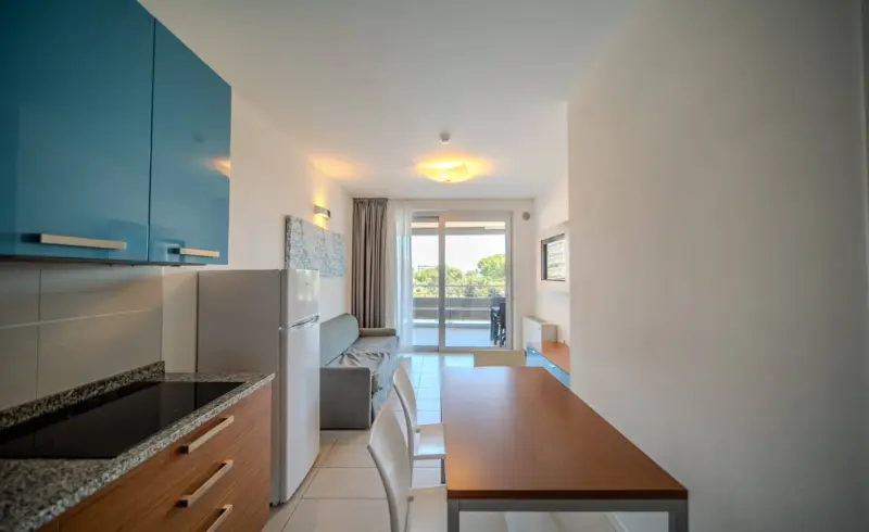 Cucina moderna con tavolo, sedie e vista esterna.