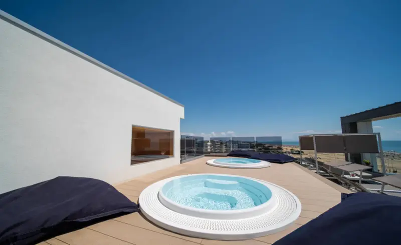 Vasca idromassaggio su terrazza con vista mare.