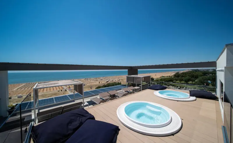 Due vasche idromassaggio su terrazza con vista mare.