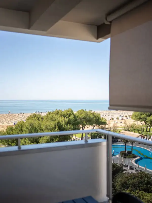 Vista mare da un balcone con piscina e spiaggia.