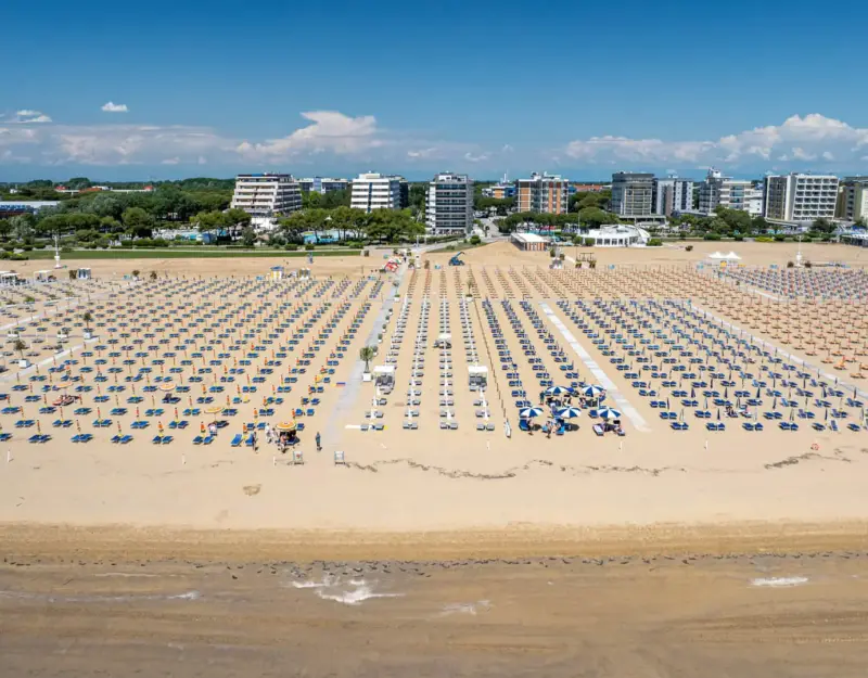 Spiaggia con file di ombrelloni a Bibione, Italia.